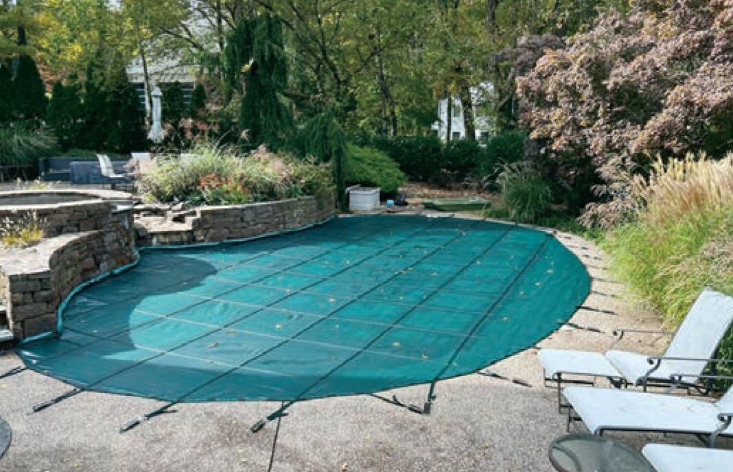 Green Classic Coverlon Mesh safety cover around a curved pool