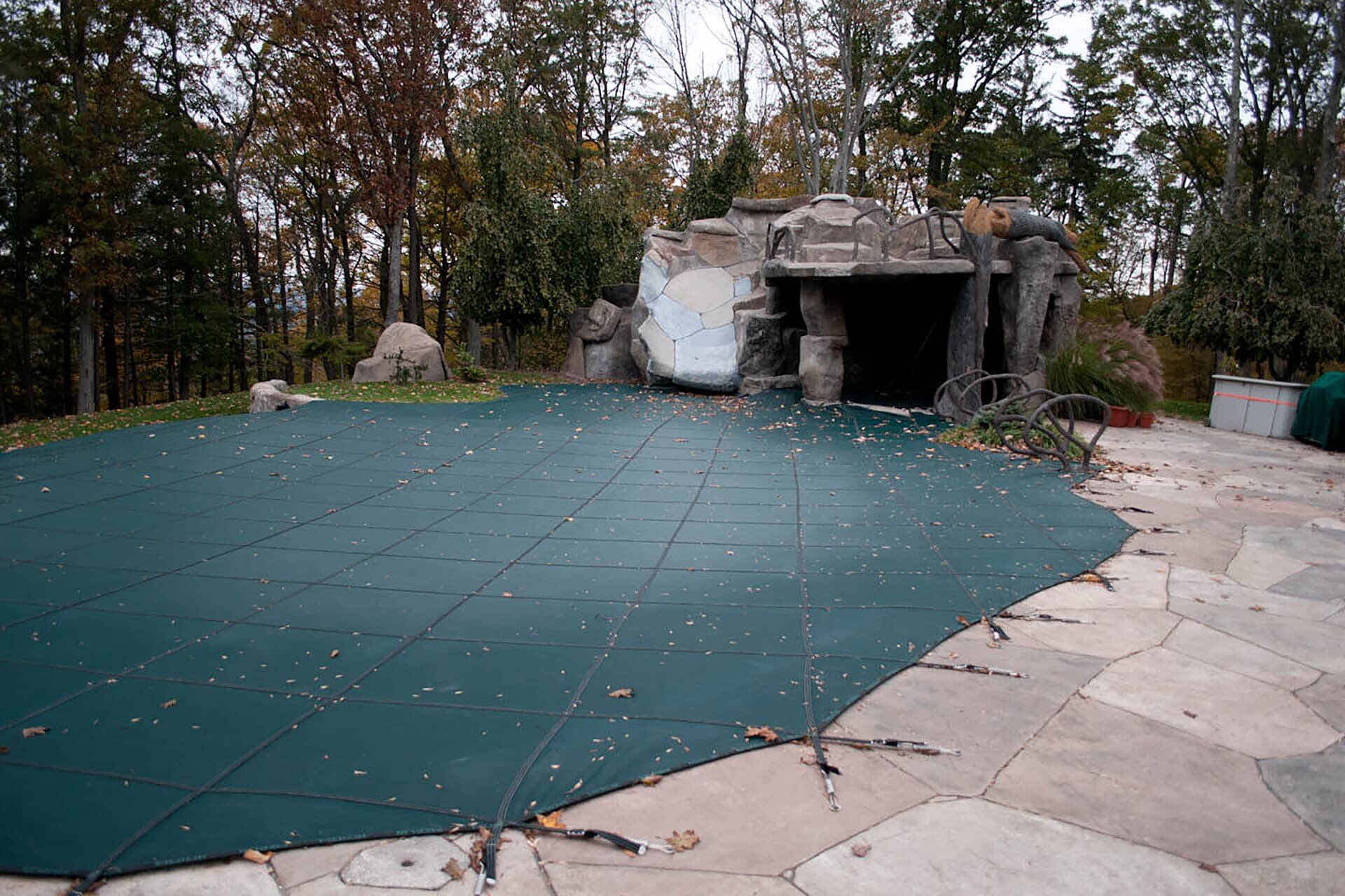 Green Merlin mesh safety cover fitted around a raised rock feature