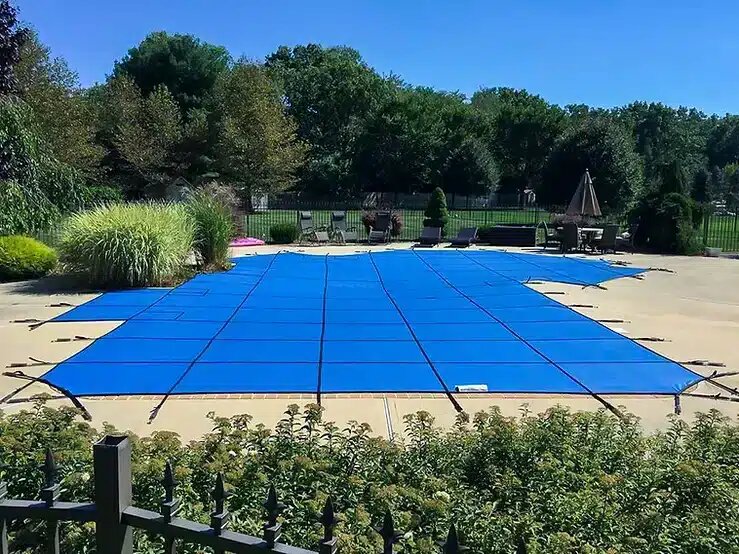 Blue Merlin Safety Solid XLS cover stretched over a backyard pool