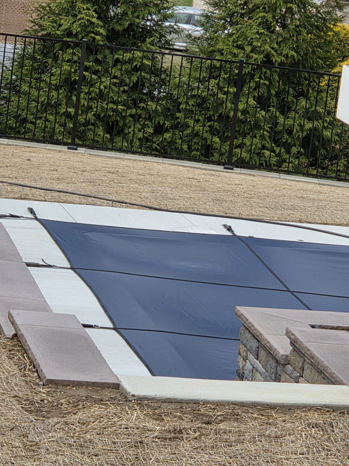 Blue Merlin SolidMesh safety cover fitted beside stone pool steps