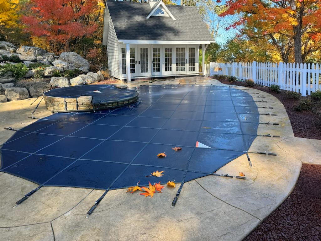 Blue MeycoLite mesh cover fitted around a freeform pool and raised spa