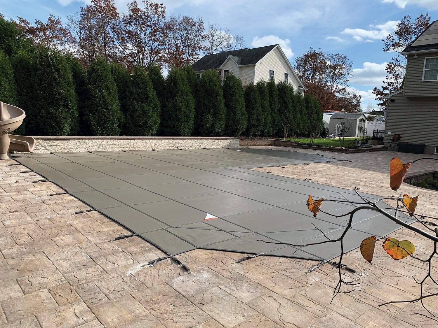 MeycoLite mesh safety cover installed over a pool with a raised wall and perimeter springs