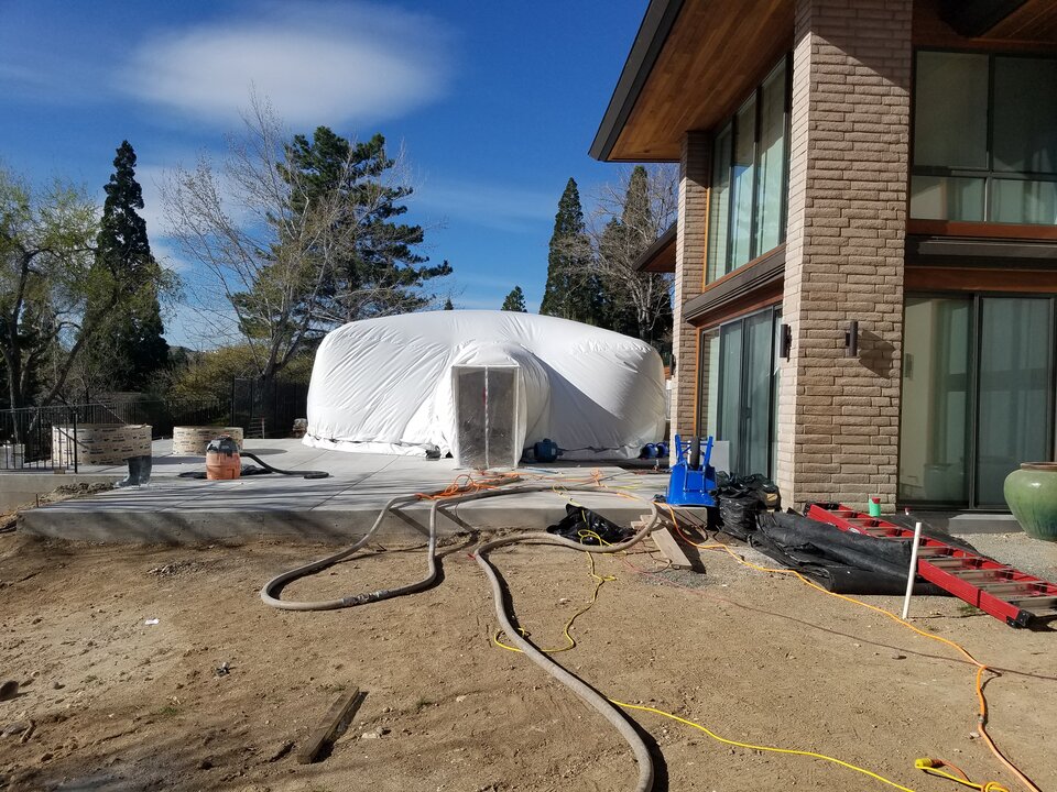 White Ameri-Dome construction enclosure over a residential pool renovation site