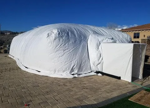 Full exterior of an inflated construction dome with its covered airlock entrance
