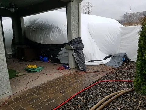 Construction dome positioned beside a covered patio