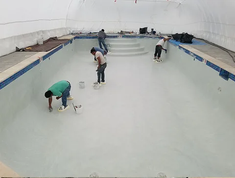 Workers applying the pool surface finish