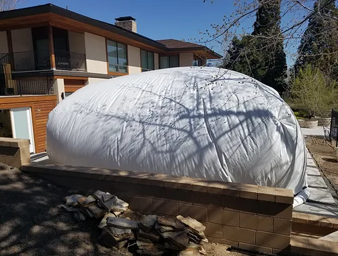 White construction dome beside a two-story house