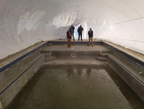 Crew inside an inflated dome over a pool work area