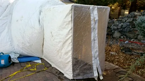 Clear-covered airlock with a zippered entrance attached to a construction dome