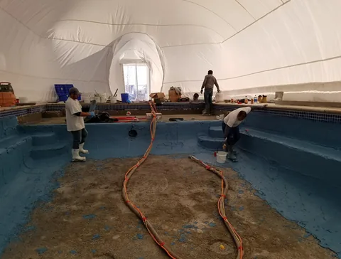 Pool crew working inside an inflated white Construction Ameri-Dome