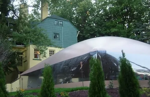 Exterior view of a pool dome with the house behind it