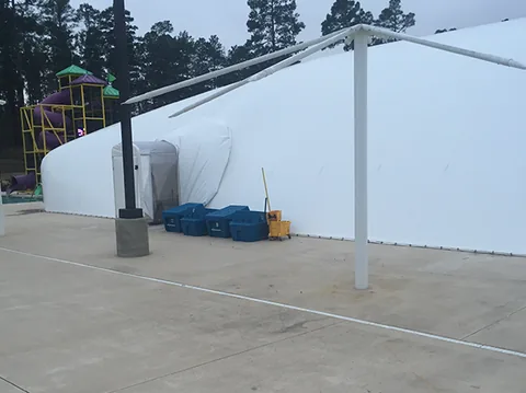 White commercial pool dome beside an outdoor pool deck