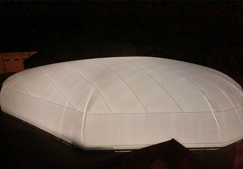 White commercial pool dome illuminated at night