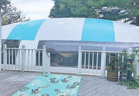 Aqua and white pool dome behind a white deck railing