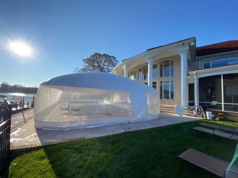 Pool dome installed beside a multi-story home and lawn