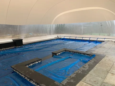 Full interior view of a covered free-form pool under the dome