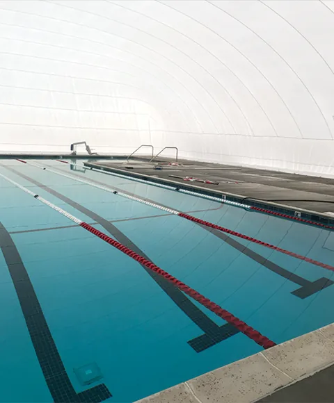 Interior lap pool beneath a white commercial dome