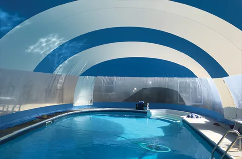 Interior view across a pool beneath a blue and white striped dome