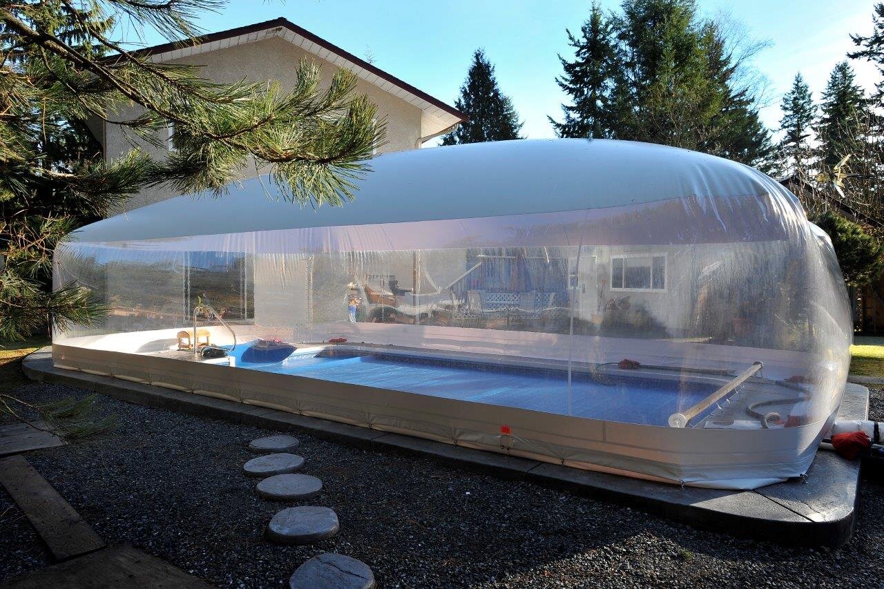 Clear Ameri-Dome enclosing a residential swimming pool and deck
