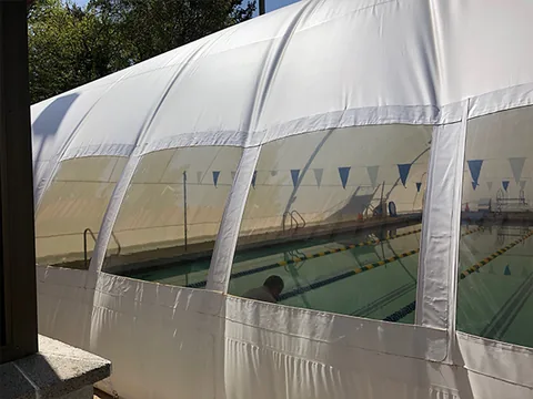 Commercial pool dome viewing panels beside a building