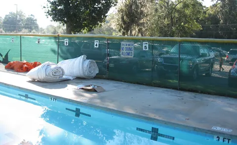 Rolled-up pool dome waiting beside the pool deck