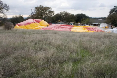 Red and yellow Sport Dome beginning to inflate on a grassy field