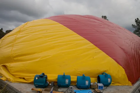 Four blue blowers inflating the Sport Dome