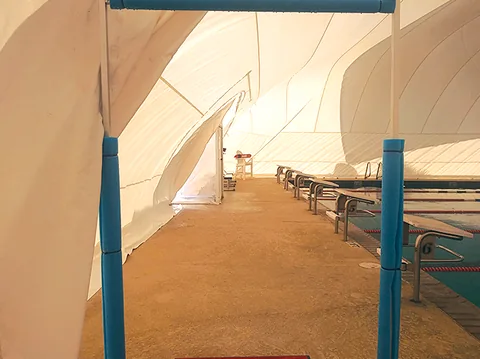 Walkway and seating inside a white commercial pool dome