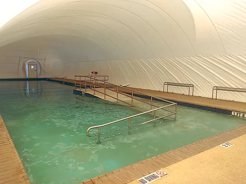 Indoor pool beneath a white commercial dome