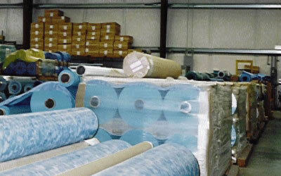 Pallets of blue and patterned vinyl rolls in the factory