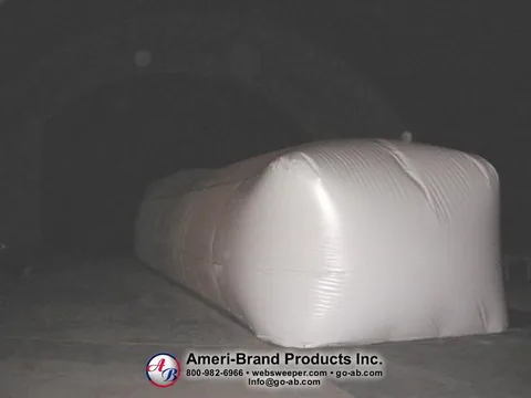 End view of a white inflatable pitching dome inside a dark Sport Dome
