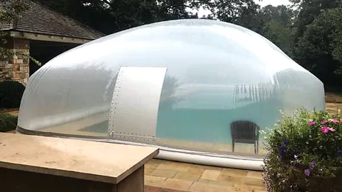 Clear water-tube pool dome with a white entry door