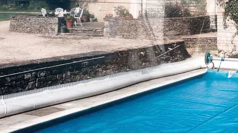 White water-tube base along the edge of an inground pool