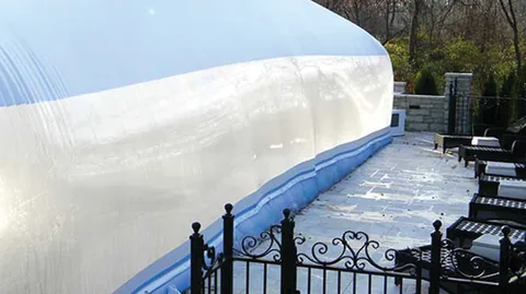 Clear pool dome secured by a blue water-tube base