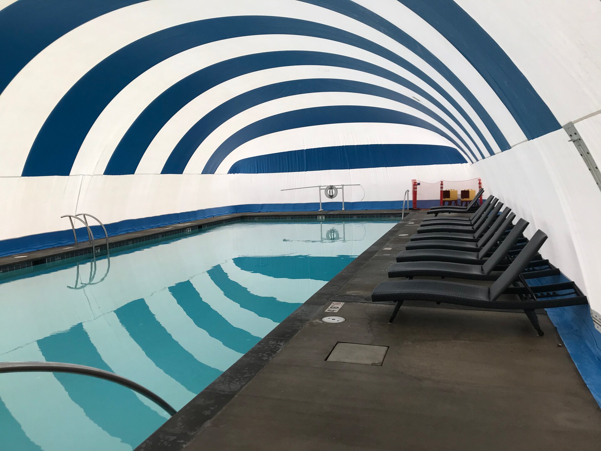 Pool edge and surrounding deck inside a blue and white Ameri-Dome