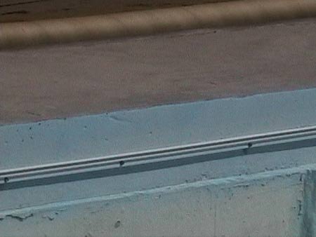 A track is mounted around the entire edge of the swimming pool.