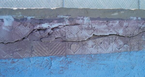Picture of inside of pool showing areas of broken off tile.