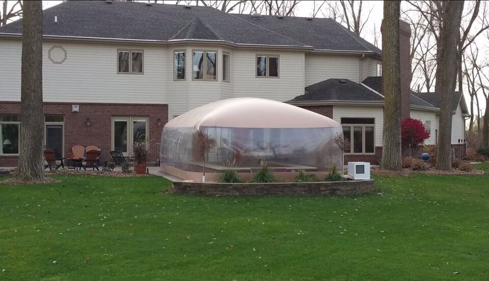 Clear-walled Swim Spa Room on the patio beside a house