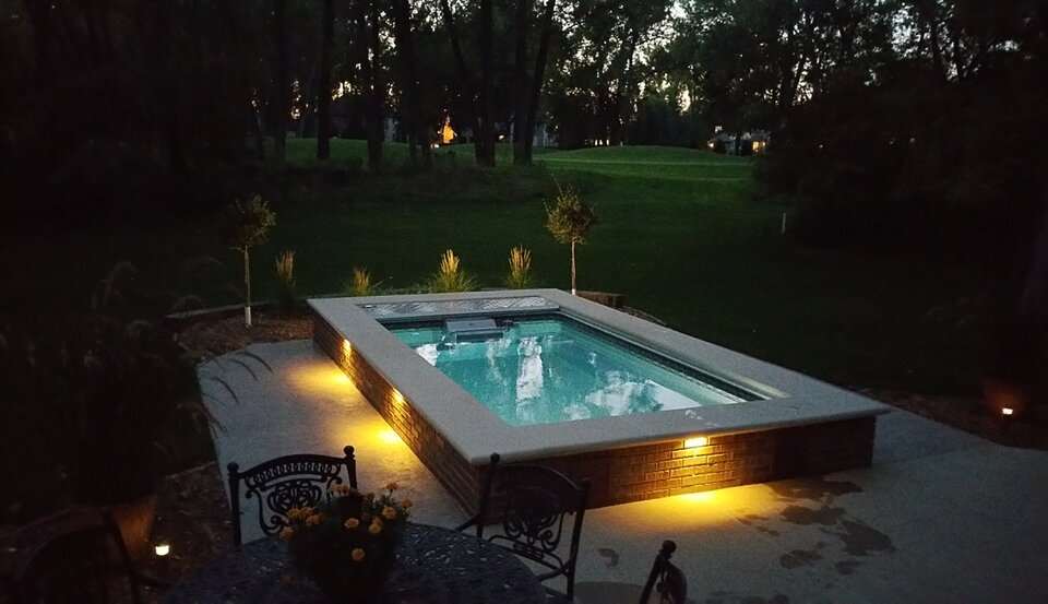 The pool and surrounding patio at dusk, without the enclosure.