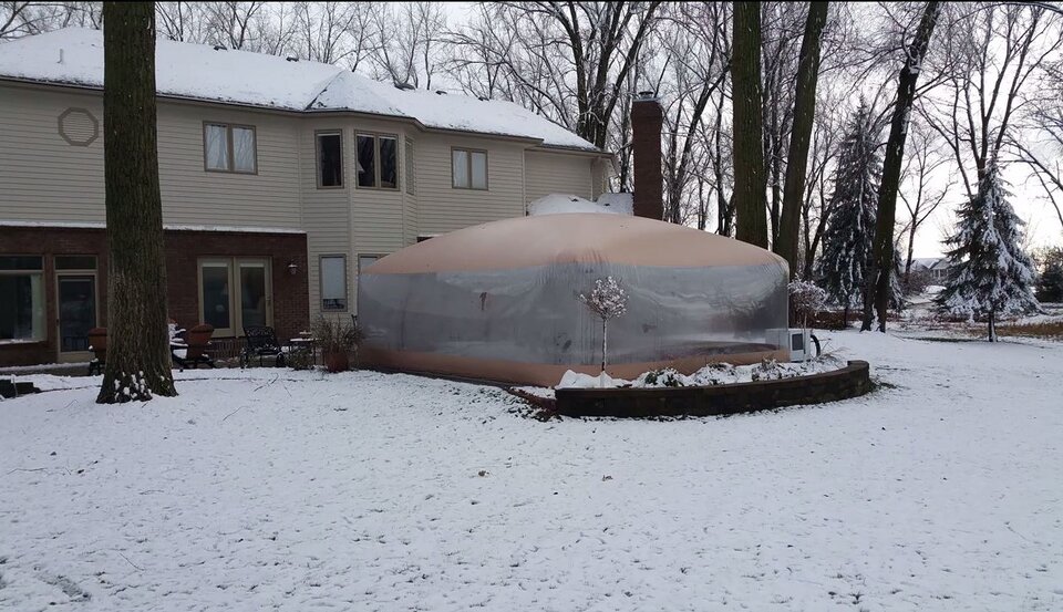 Installed Swim Spa Room beside the house with snow on the surrounding lawn and house roof