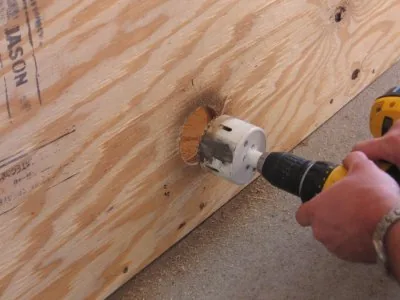 Drilling an opening through the wooden tank wall