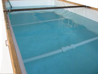 Filled tank with supports spanning its width