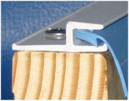 Liner bead seated in top-mounted track along a wooden tank wall