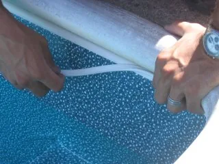 Pressing vinyl T-Lock into the track above the liner bead
